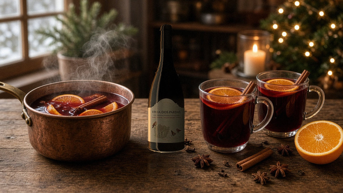 Botella de Quinta do Piloto Vinha dos Pardais Tinto junto a una olla de cobre y tazas de vino caliente con naranja y canela